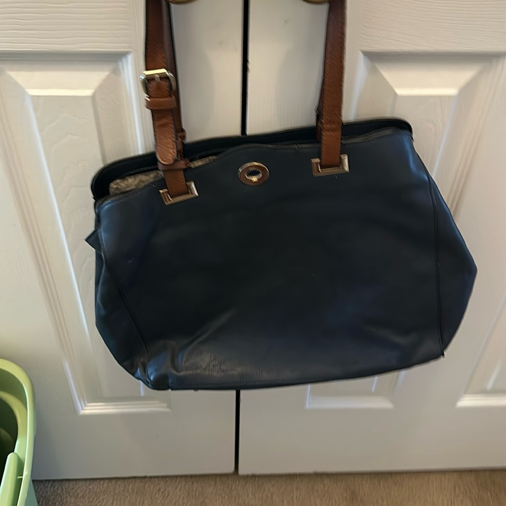 Navy large bag with a lot of pockets and brown hands